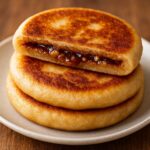 Korean sweet pancake hotteok filled with brown sugar and nuts served hot as a popular winter street food